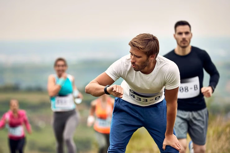 man-checking-watch-during-race-with-other-runners-in-background